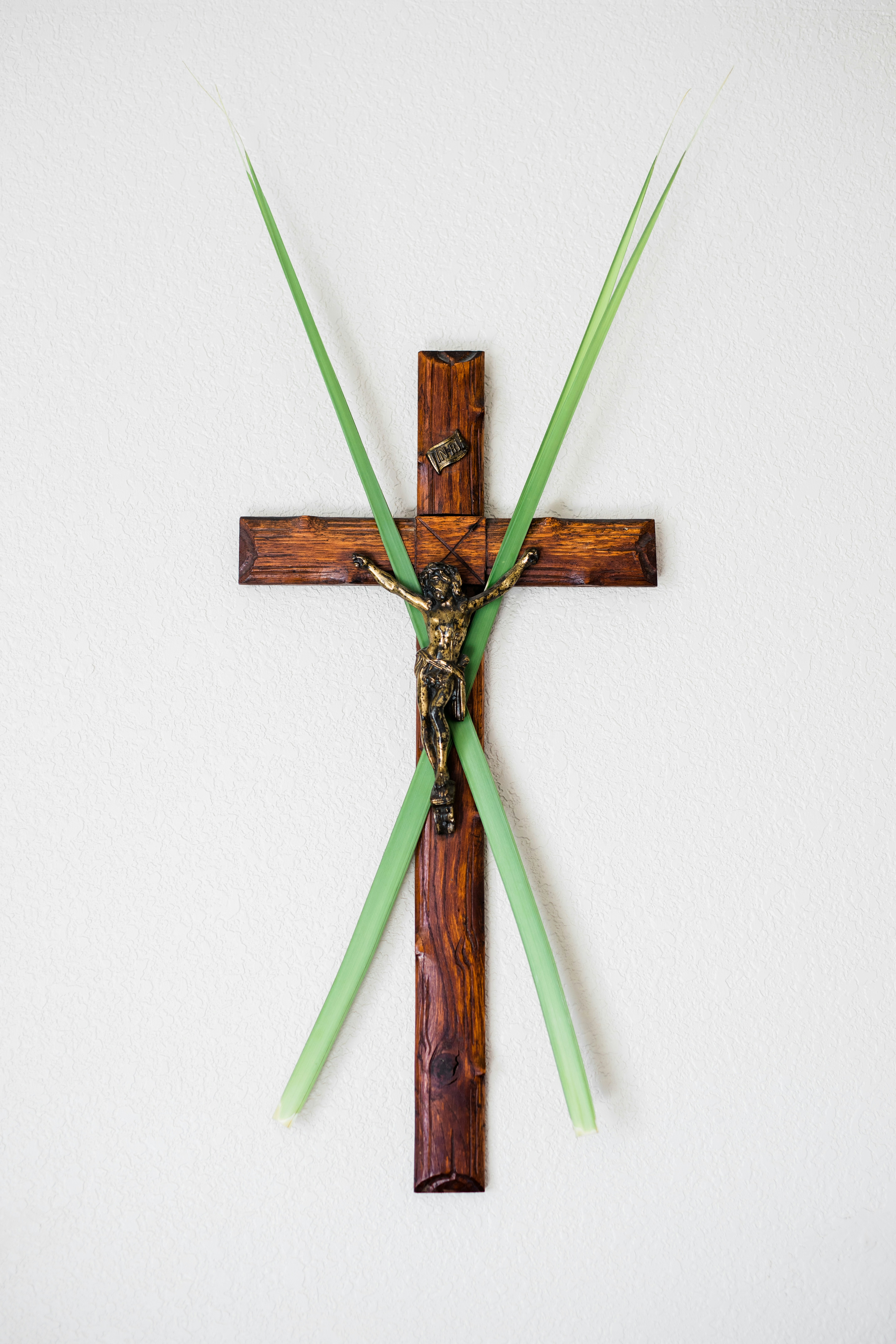 A crucifix with palm leaves laid over the top of it