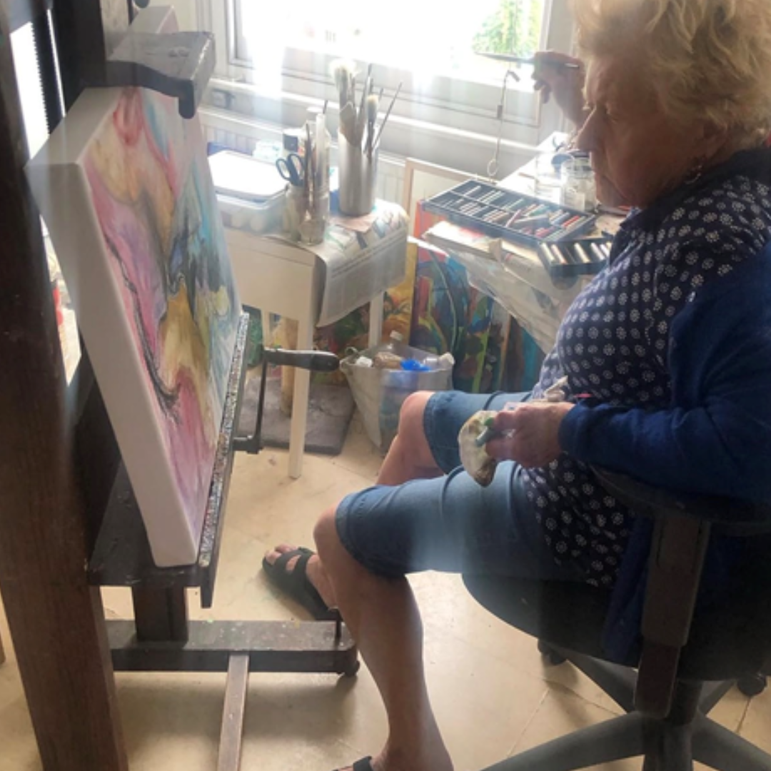 Artist Elizabeth Duncan Meyer sitting painting in her studio