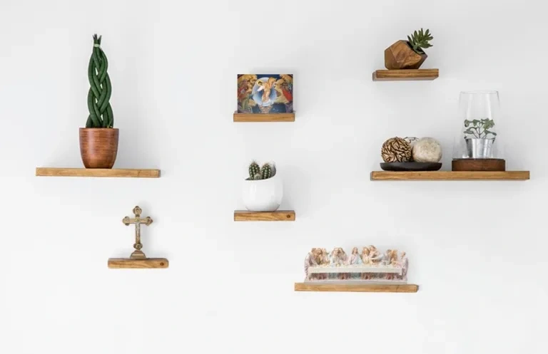 A selection of Christian home gifts placed on shelves with a white wall