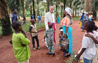 A bishop talking to an African woman surrounded by children