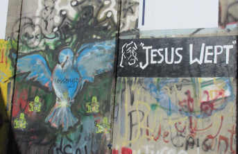 Graffiti on a wall in Bethlehem depicting a large blue bird next to the words 'Jesus Wept'