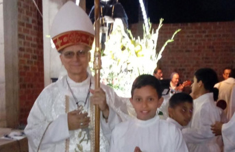 Pope Leo XIV standing next to young altar boy with a group of children behind them