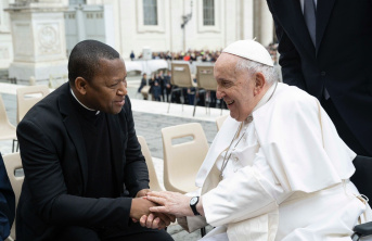 Two seated men holding hands - Pope Francis meeting Fr Joseph Fidelis