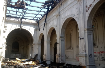 Interior of a church after a fire with ceiling completely burned through and debris on the floor