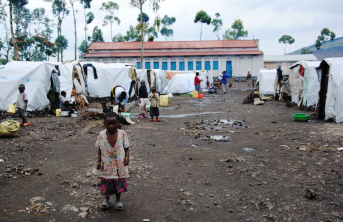 A small African child standing in the middle of a displacement camp