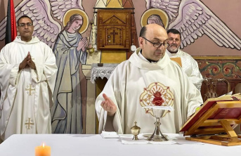 A Father delivering mass at a church altar dressed in white religious clothing