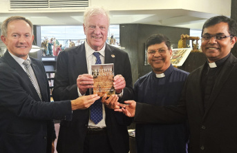 Four adult men holding a book titled 'Another Country'