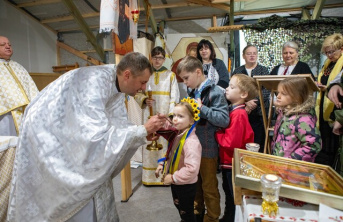 A priest offering communion to a young Ukrainian girl