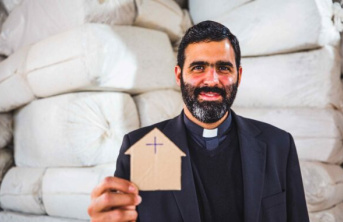 Father Lucas Perozzi shows a picture of a small cardboard house 