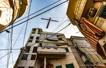 A wooden cross hanging next to the electricity wires in Bourj Hammoud, Beirut