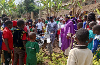 Parishioners and a priest gathered around the new motorbike in Bamenda