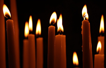 A collection of lit candles in darkness