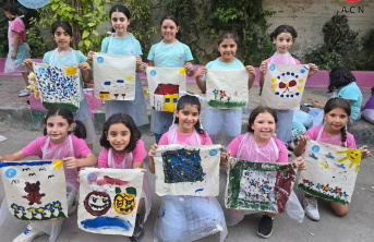 Syrian children with hand painted artwork from summer camp