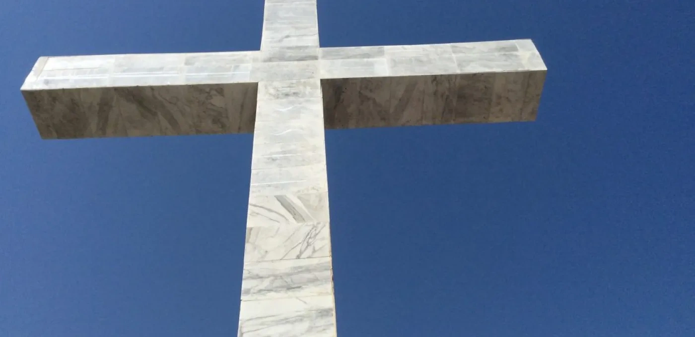 Large stone cross against a blue sky background