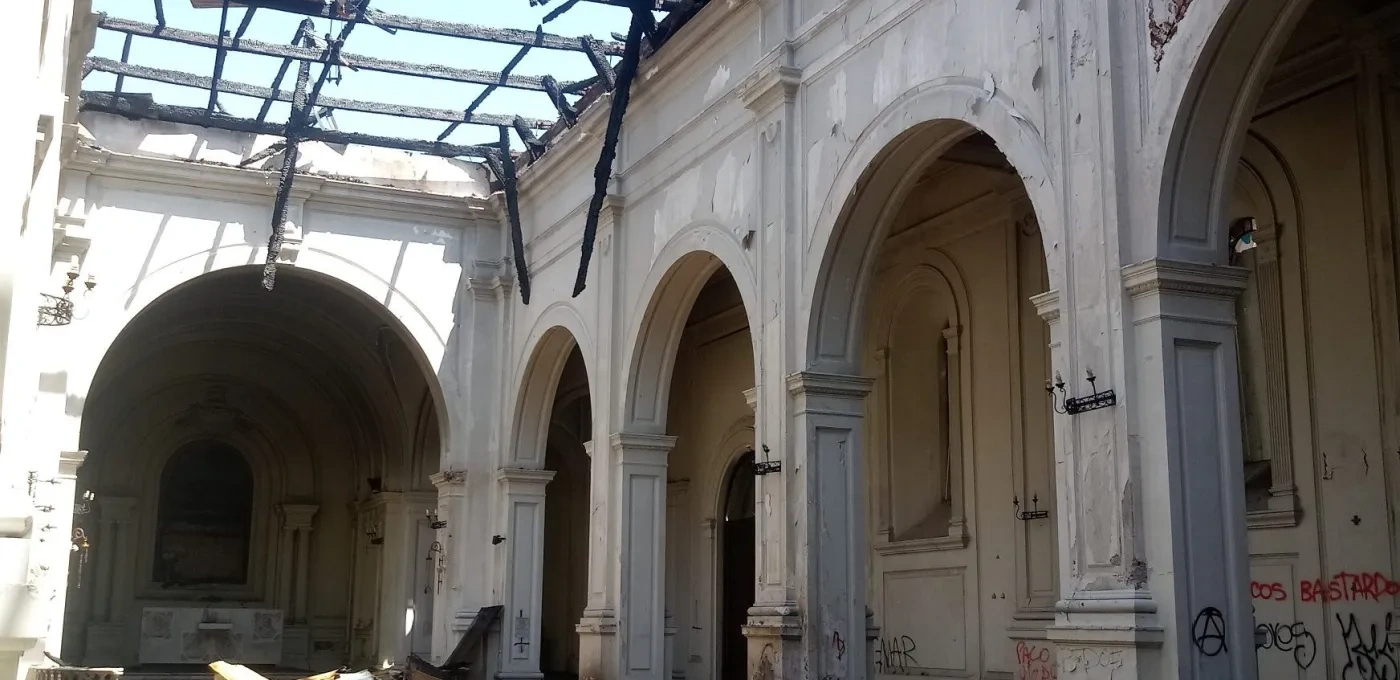 Interior of a church after a fire with ceiling completely burned through and debris on the floor