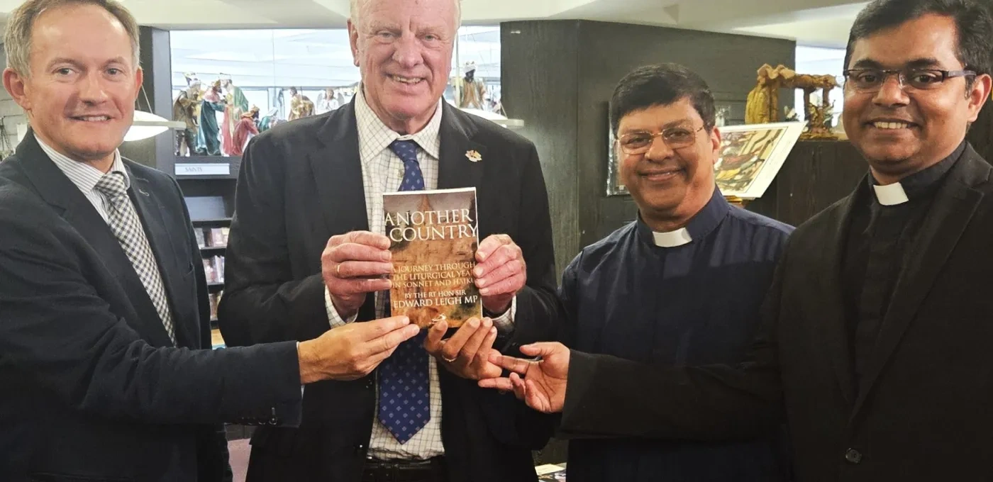 Four adult men holding a book titled 'Another Country'