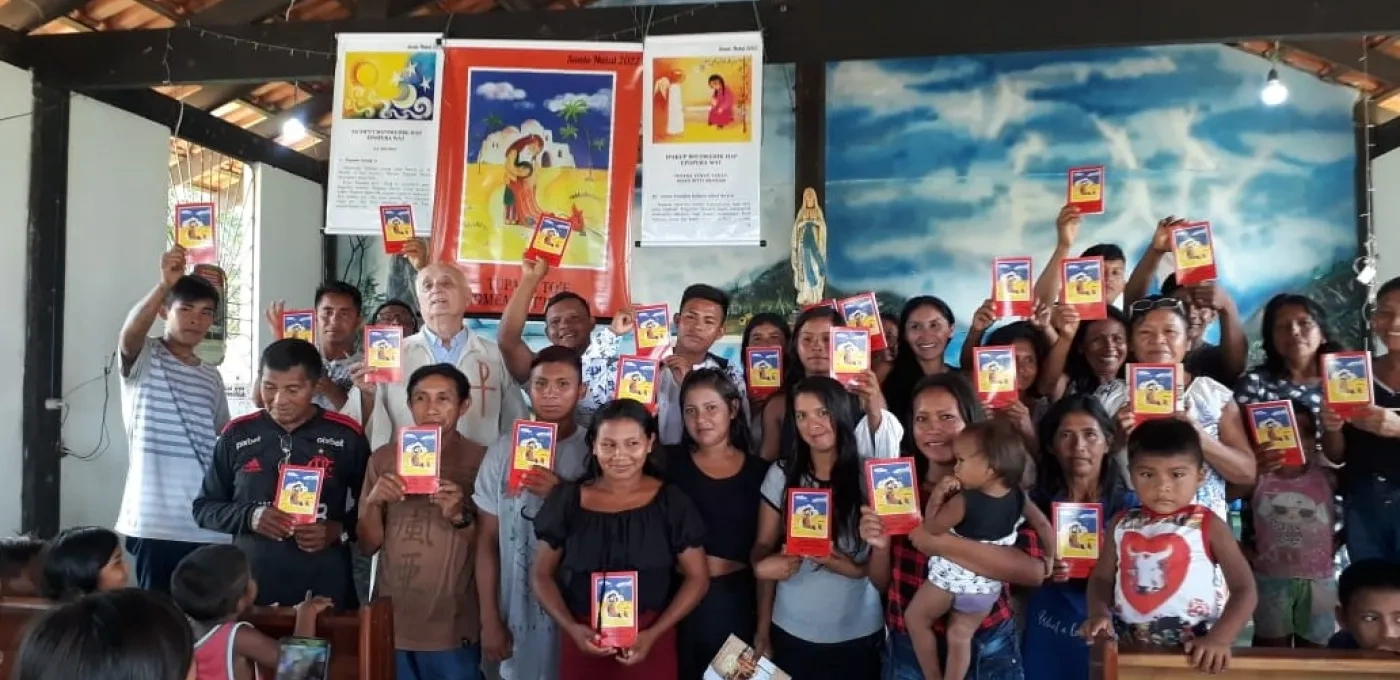 Group of people holding a children's bible inside a church with wooden beams