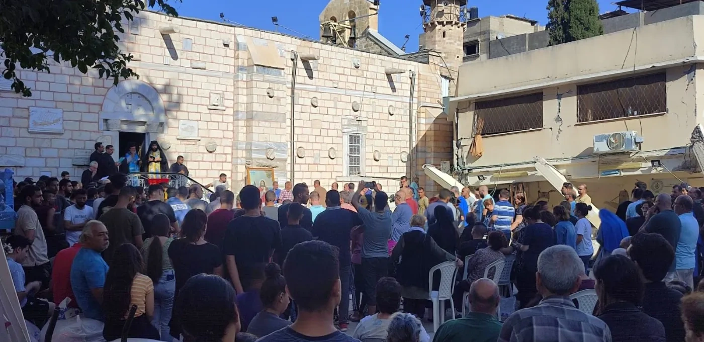 People gathered in a square in front of a church.