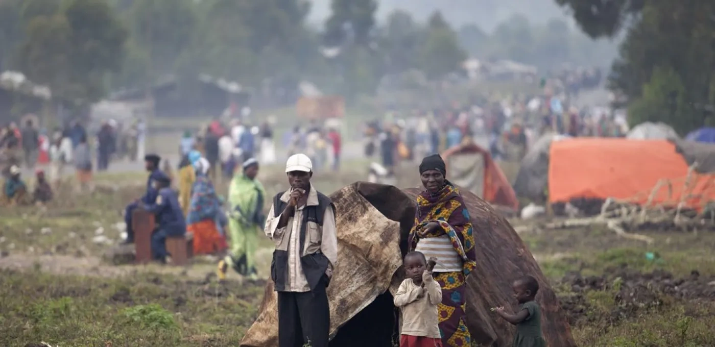 people in an open field with a tent and young children