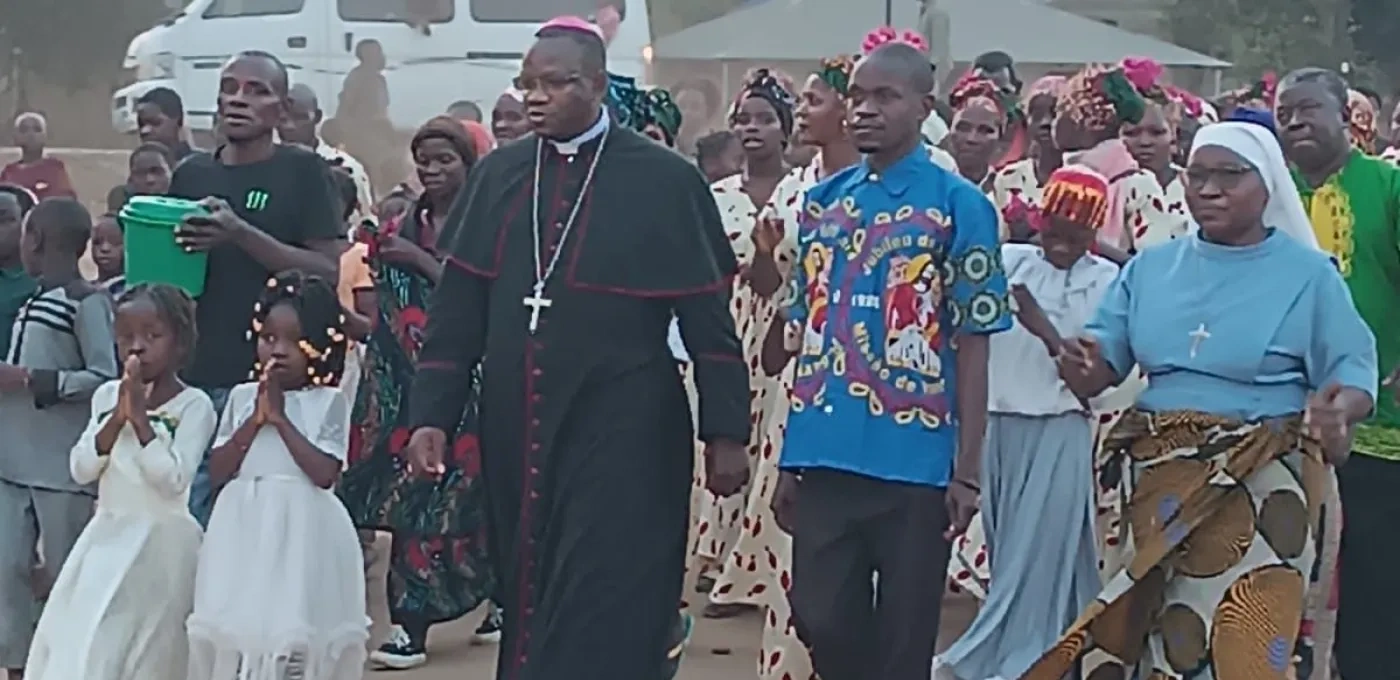 A priest and congregation walking on a road