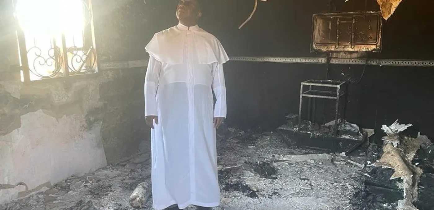 Priest standing in a arson damaged Church