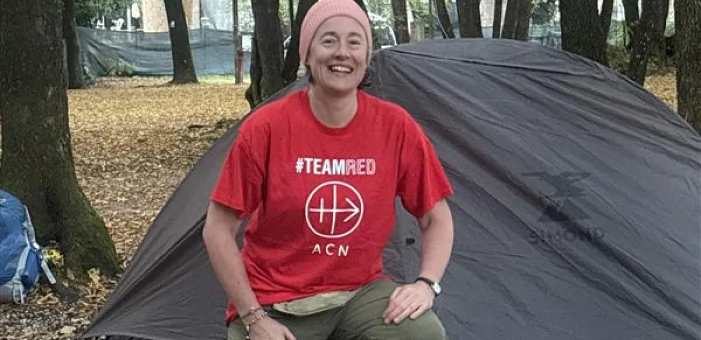 Eileen Murray kneeling in front of her tent in the Cascata delle Marmore forest in Italy