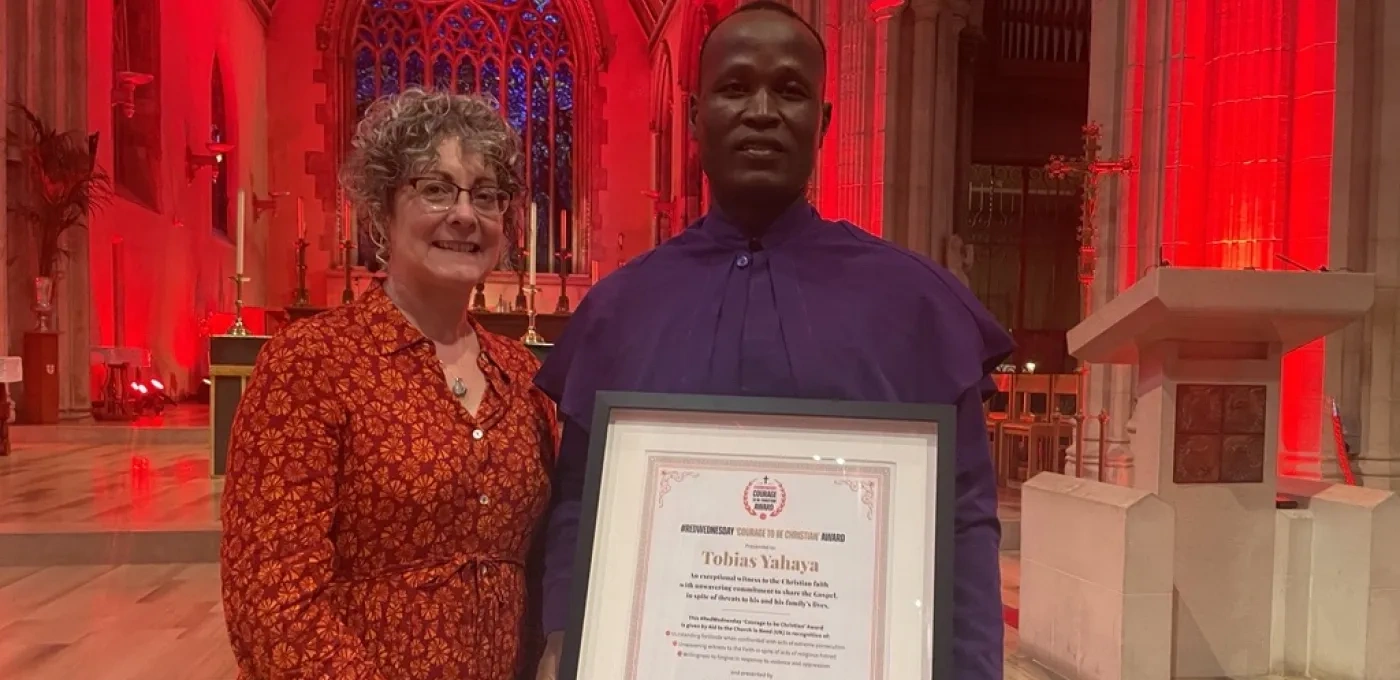 Caroline Hull ACN National Director and Tobias from Nigeria holding his Courage to be Christian award after #RedWednesday Mass.