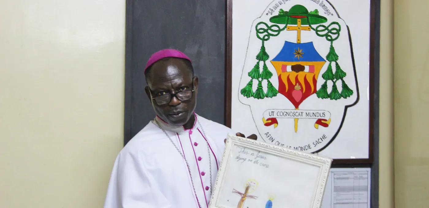 Bishop Theophile Nure from Burkina Faso in front of his coat of arms