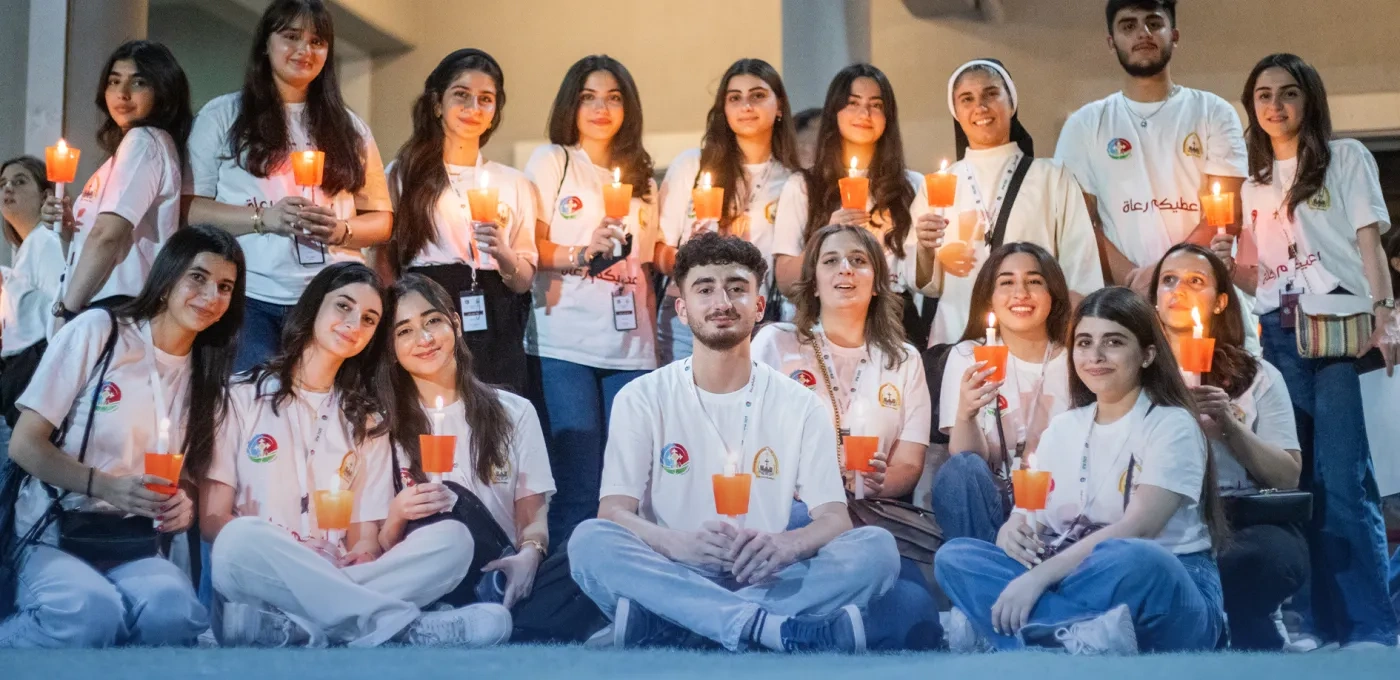 University students in Iraq sitting and standing together holding candles