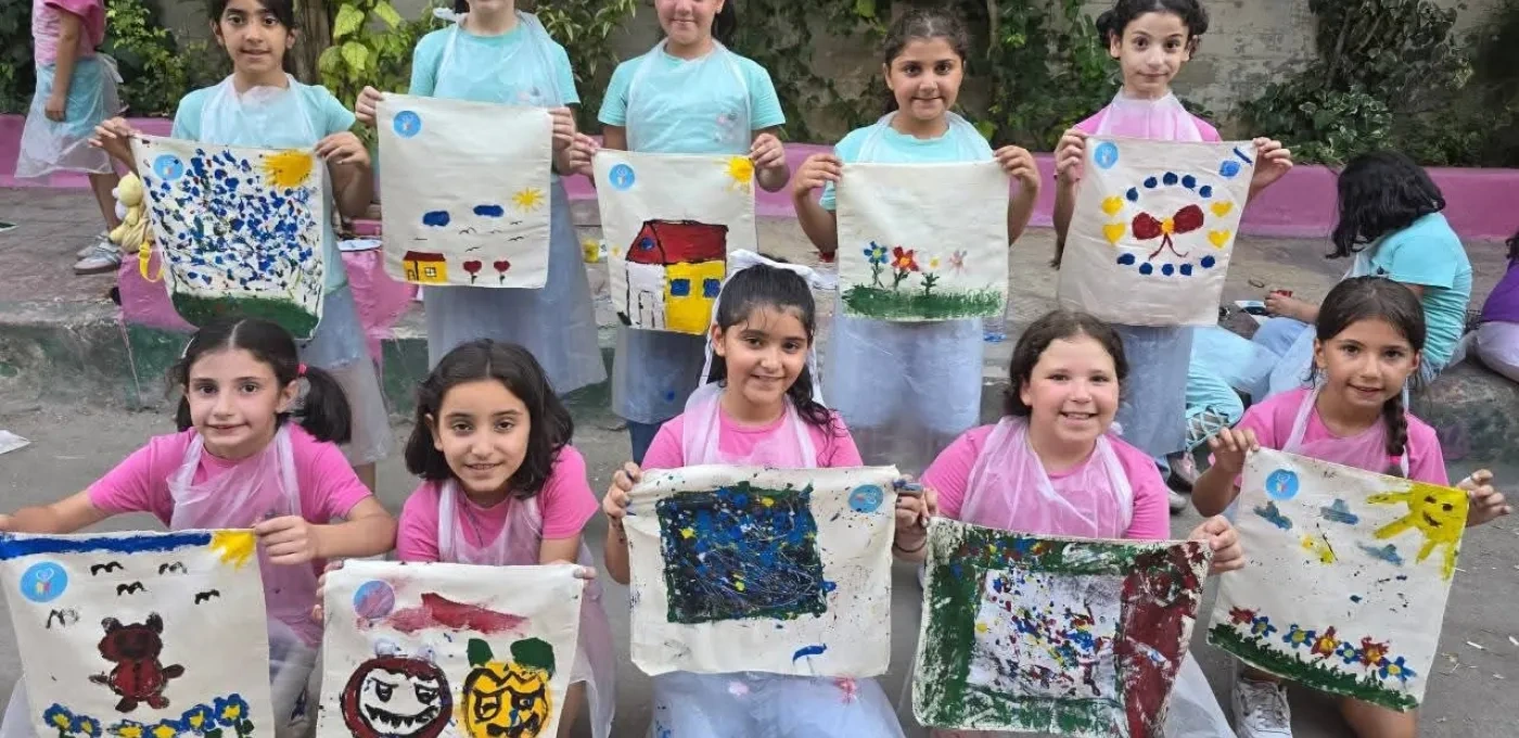 Syrian children with hand painted artwork from summer camp