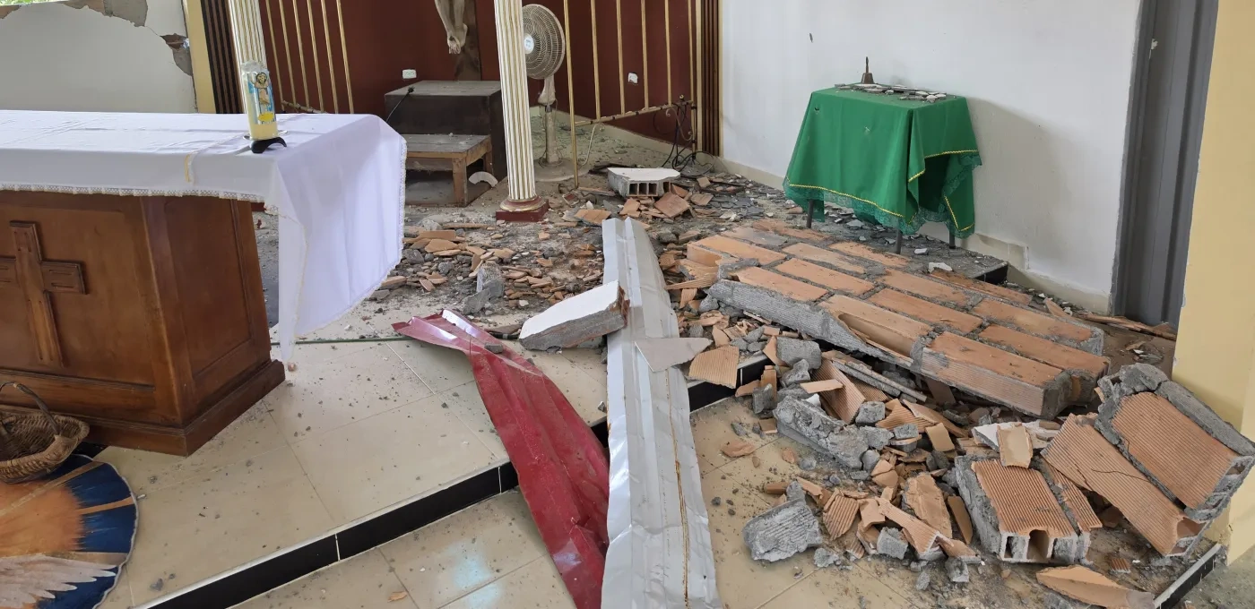 A church that has been damaged with brick walls laying on the floor