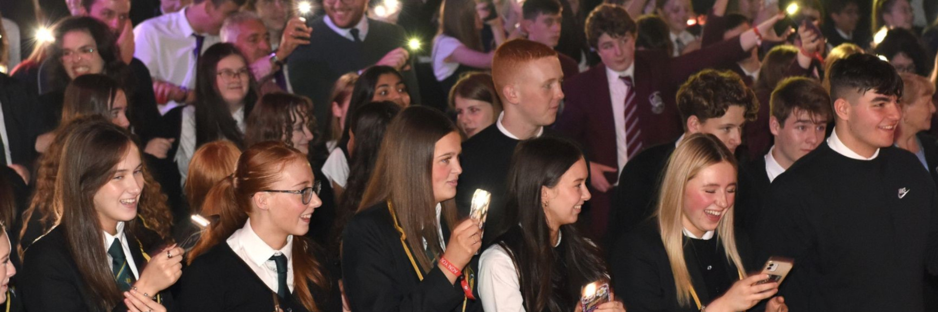 Secondary school students holding lights at ACN youth rally