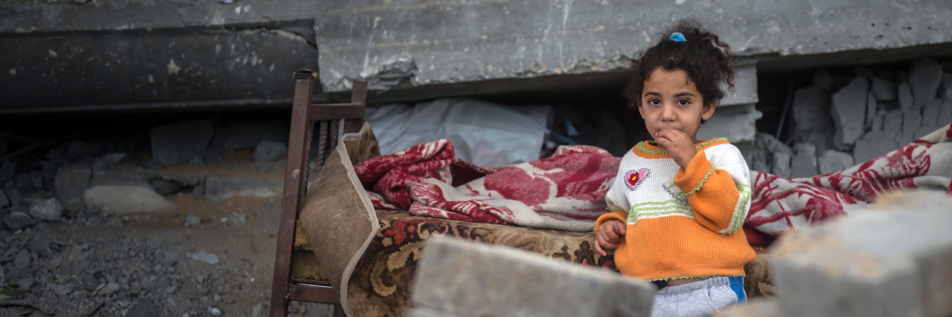 Girl standing amongst rubble in the Holy Land