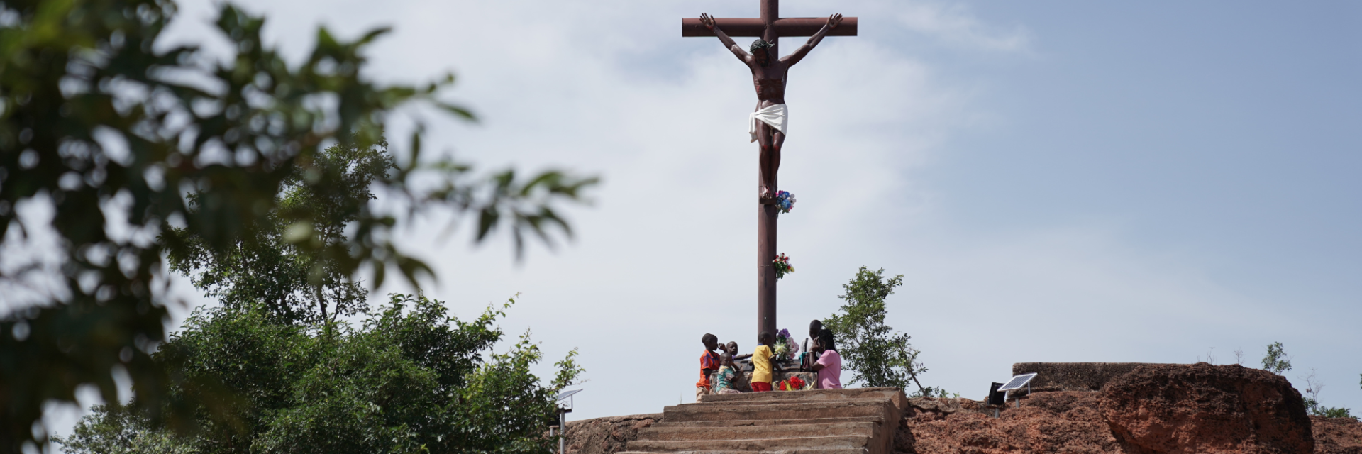 Children sitting together under a Crucifix