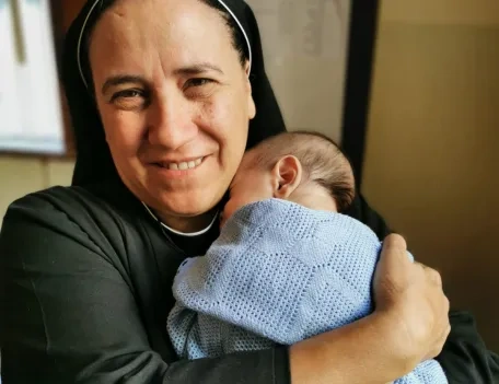 Sister holding a small baby that has been displaced in Lebanon