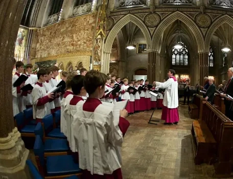 Choir singers performing at a Mass within a Church as parishioners join in singing.