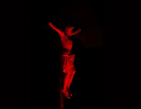 Jesus on a crucifix lit up in red
