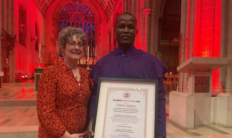 Caroline Hull ACN National Director and Tobias from Nigeria holding his Courage to be Christian award after #RedWednesday Mass.