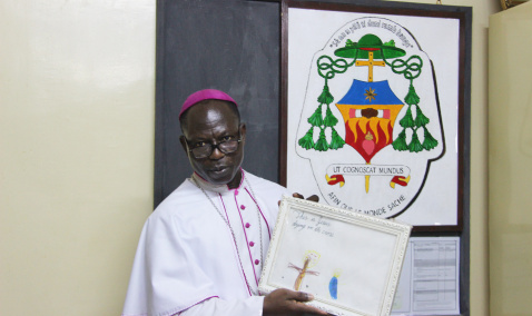 Bishop Theophile Nure from Burkina Faso in front of his coat of arms