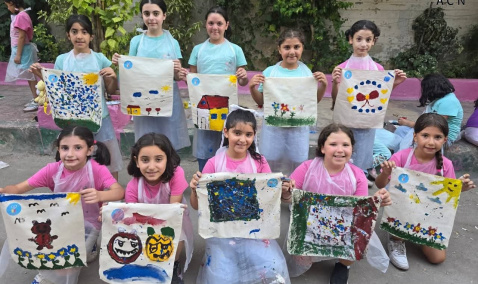 Syrian children with hand painted artwork from summer camp