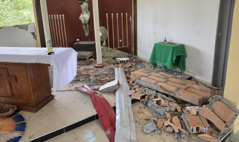 A church that has been damaged with brick walls laying on the floor