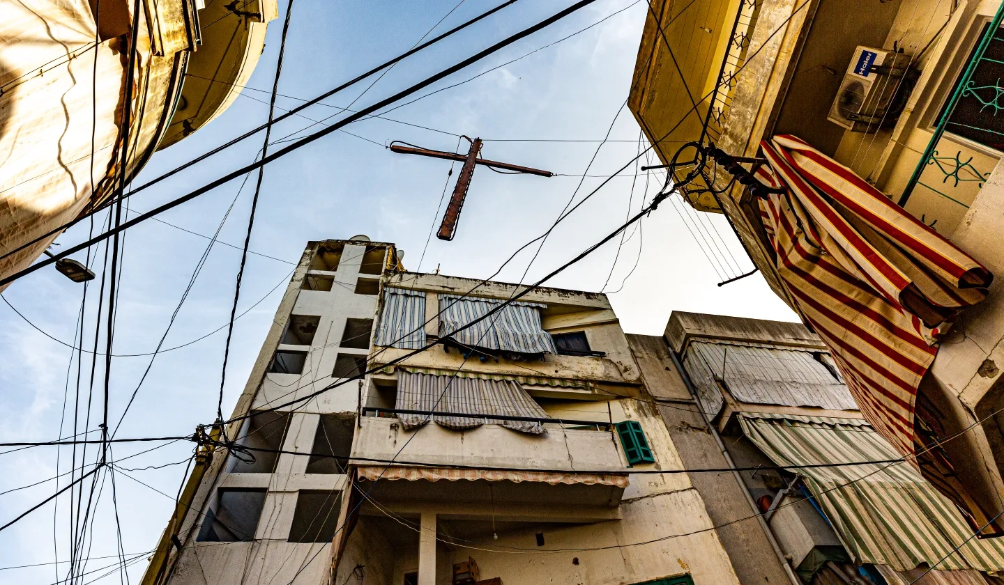 A wooden cross hanging next to the electricity wires in Bourj Hammoud, Beirut