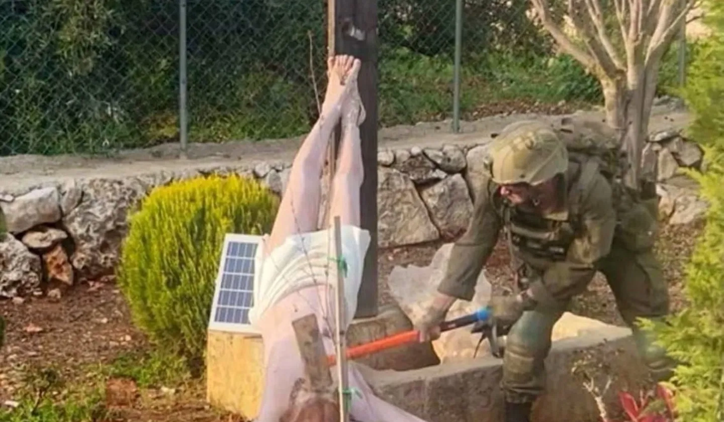 IDF soldier hitting crucifix with hammer