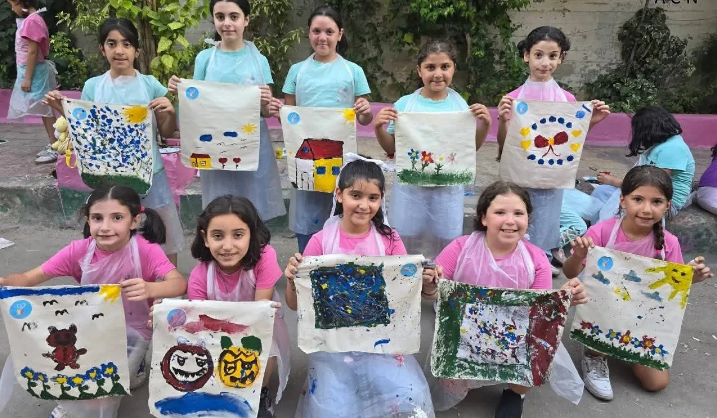 Syrian children with hand painted artwork from summer camp