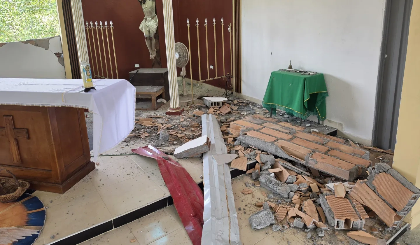 A church that has been damaged with brick walls laying on the floor
