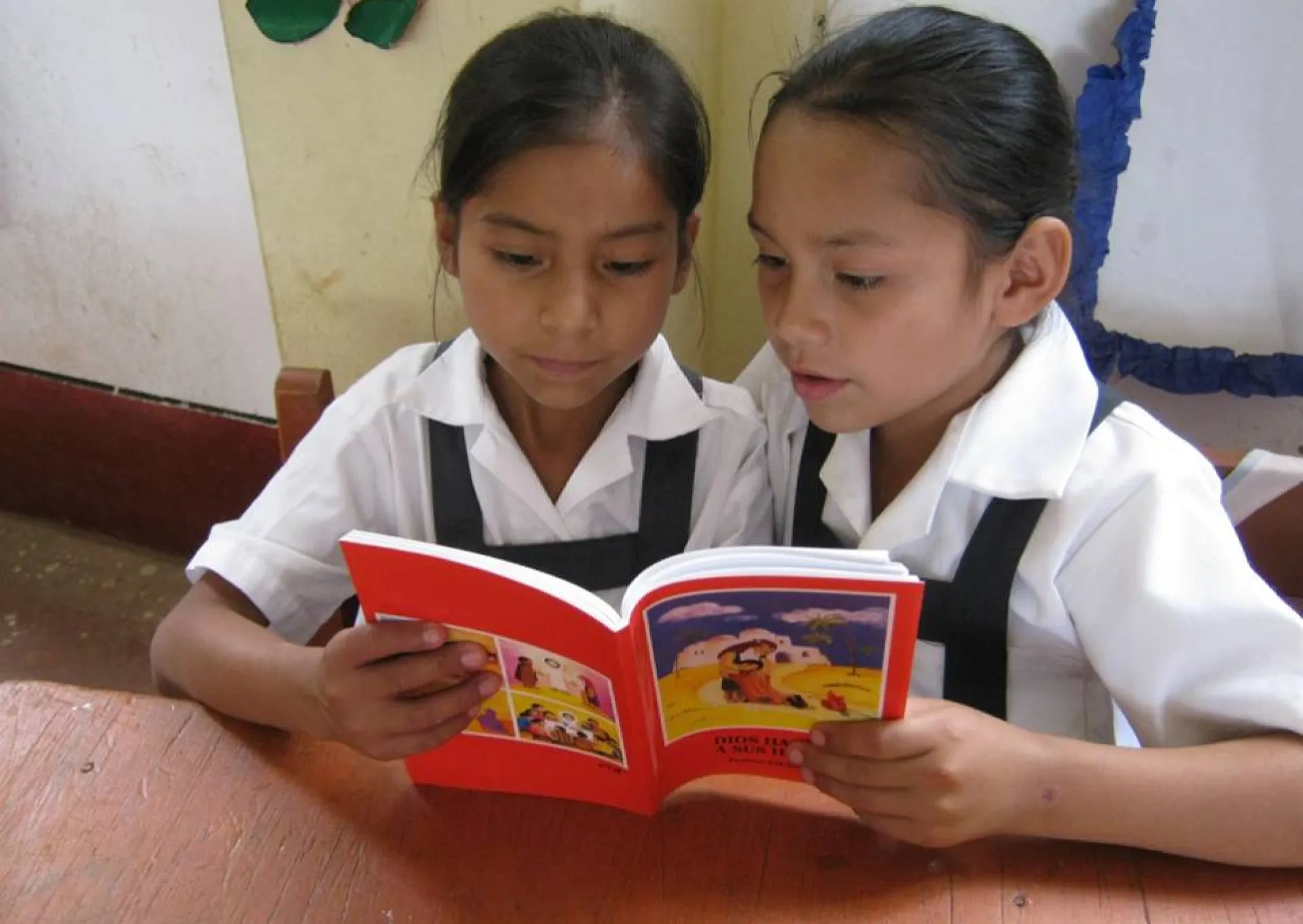 Two girls reading an ACN's child bible