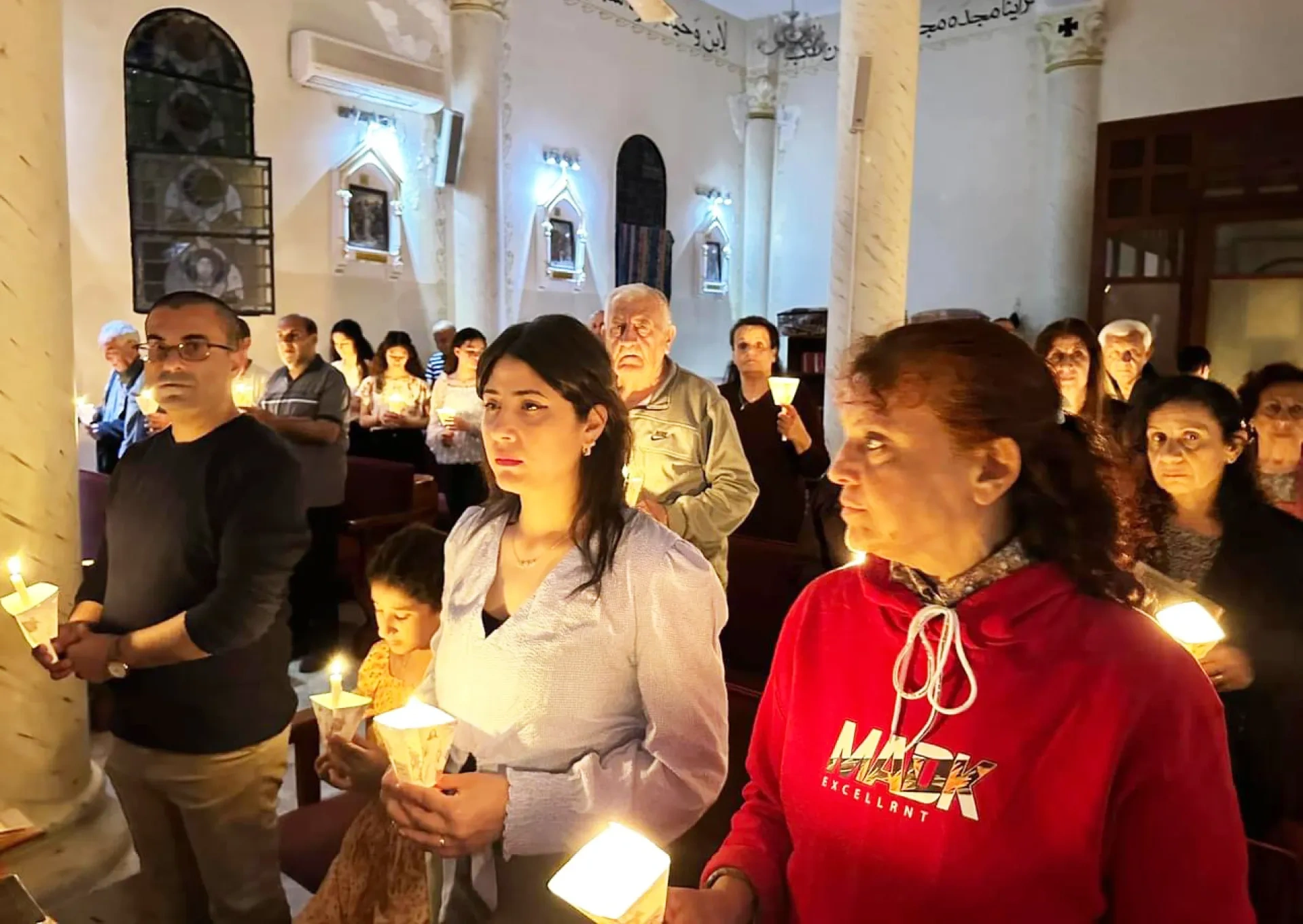 People praying in Mass in the Holy Land