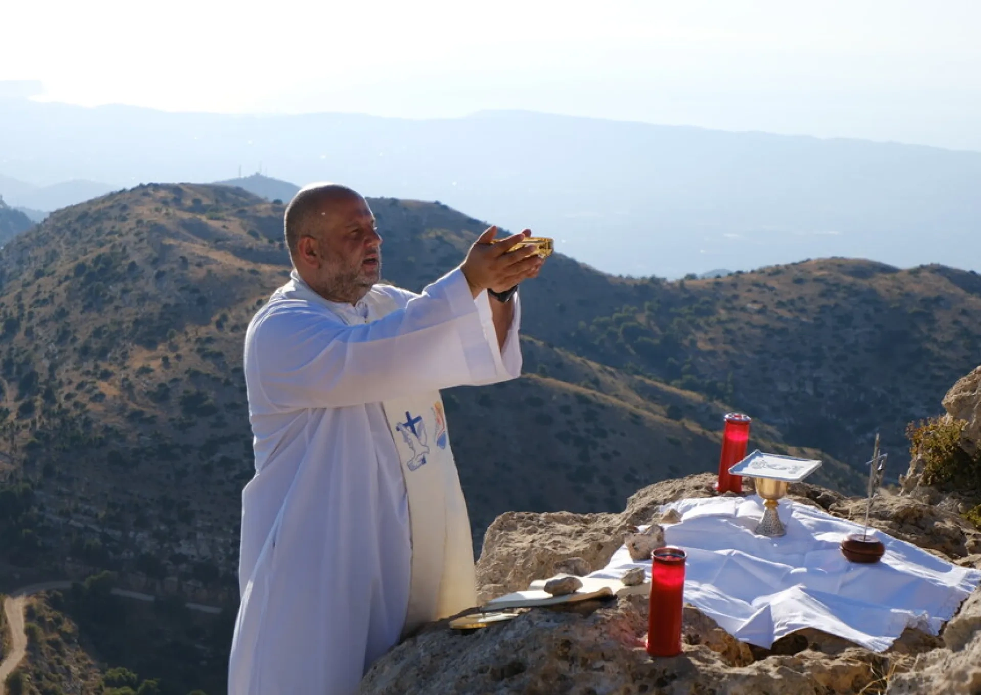 A priest offering a Mass outside in the Lebanon mountains