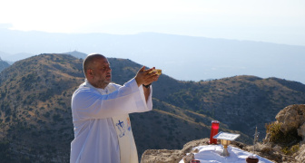 A priest offering a Mass outside in the Lebanon mountains