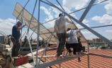 Group of men fitting solar panels to a rooftop in Syria